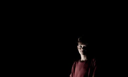 Portrait image of a boy at night in the dark with one light sourceの写真素材