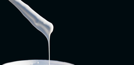 Dripping white thick paint on a dark backgroundの写真素材