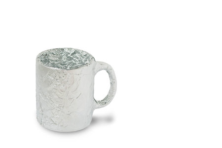 Kitchen utensils mug wrapped in foil on a white backgroundの写真素材