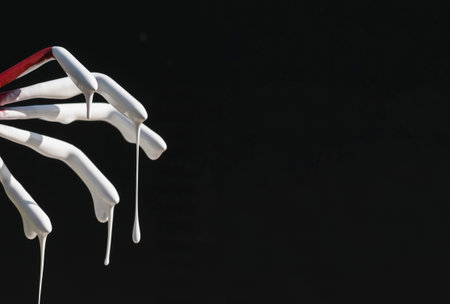 Dripping viscous white paint on a dark background
