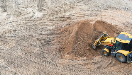 A construction site with a lot of sand.Heavy machinery is working