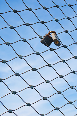 Padlocks on metal meshの写真素材