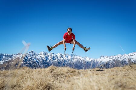 Man jumping on the mountains in a beautiful sunny day, italian Alps. Italyの写真素材