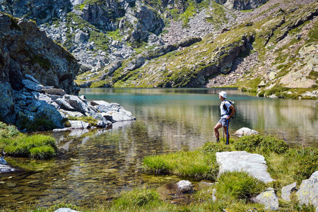 backpacker resting near a mountain lake in a beautiful summer's dayの写真素材