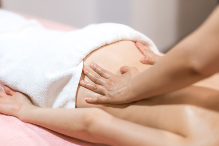 Spa woman. Female enjoying relaxing back massage in cosmetology spa centre. Body care, skin care, wellness, wellbeing, beauty treatment concept.の写真素材