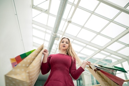 Beautiful girl with shopping bags walking at the mallの写真素材