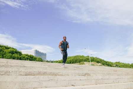 African young man athlete steps up with energy in bleachersの写真素材