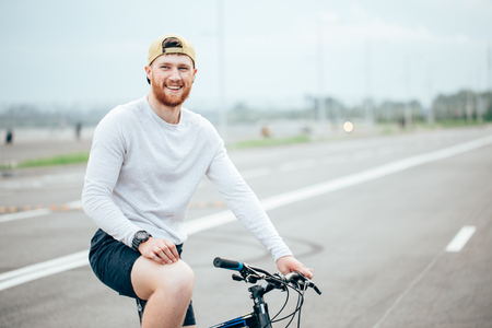 Businessman riding bicycle to work on urban street in morningの写真素材