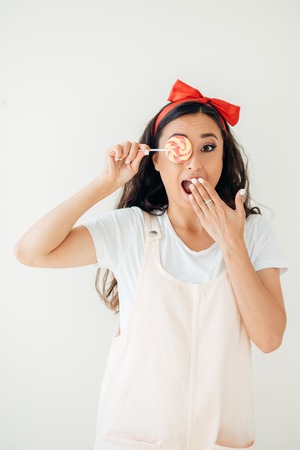 Beautiful sexy woman model with pink lips and lollipop on white background.の写真素材