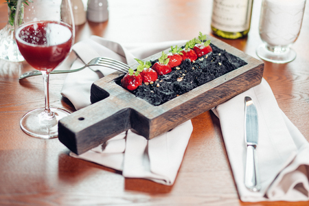Roasted red beef ribs, meat on bone, with colorful vegetables and black rice on board. Modern molecular gastronomyの写真素材