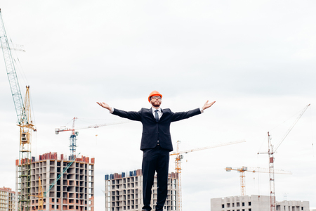 happy and confident architect with safety helmet in construction siteの写真素材