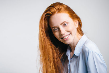 Headshot Portrait of happy ginger girl with freckles smiling looking at cameraの写真素材