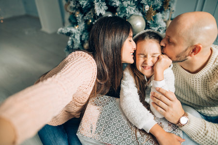 Cheerful family making comic xmas selfie and showing tongues
