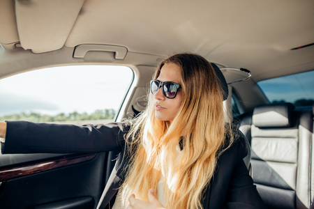 happy business woman in a car is looking at cameraの写真素材