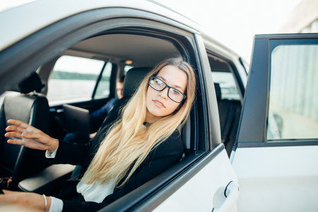 happy business woman in a car is looking at cameraの写真素材