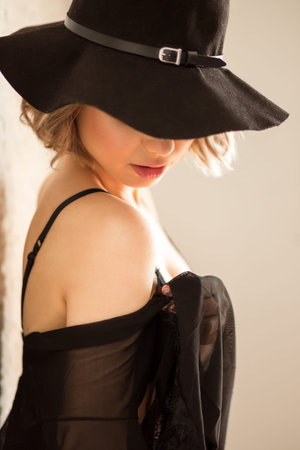 sexy girl, in black bikini lingerie with hat and stocking, sitting in ambient