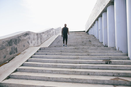 African young man athlete steps up with energy in bleachersの写真素材
