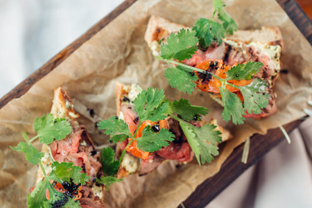 Sandwich with cereals bread and salmon on dark marble background
