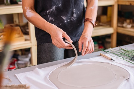 artist woman hands working red clay to create handcraft artの写真素材