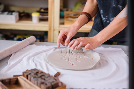 artist woman hands working red clay to create handcraft artの写真素材