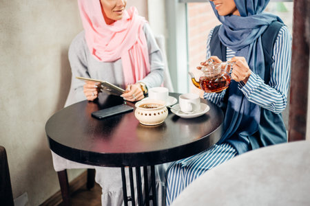 pretty muslim woman use tablet in cafe