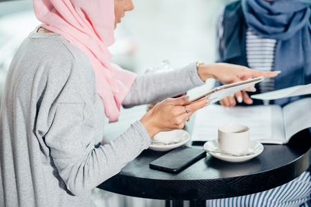 Portrait of beautiful Arabic Muslim girl using tabletの写真素材