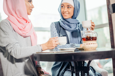 Pretty young Muslim woman with a cup of coffee or tea in actionの写真素材