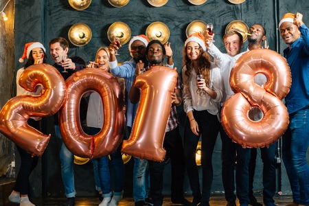 Happy smiling people holding golden number balloons, 2018 year symbolの写真素材