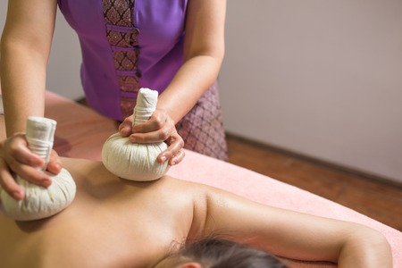Thai Ball Massage. Woman in day SPA getting thai herbal massage.の写真素材