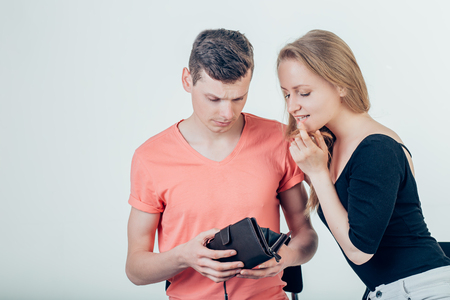 Nerdy man is trying to hide money from his wife because she want to spend it allの写真素材