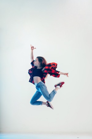Young beautiful dancer posing in white studioの写真素材