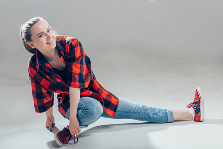 Young beautiful dancer posing in white studioの写真素材