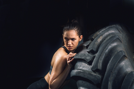 Strong girl flipping a tire in gym.の写真素材