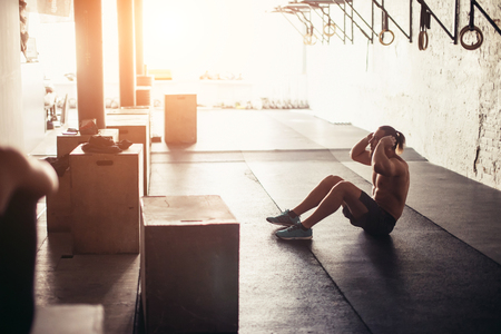 Muscular man exercising doing sit up exerciseの写真素材