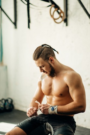 man getting prepared for the training, wrapping her hands with bandage tapeの写真素材