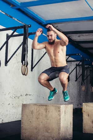 Fit man doing box jumps in a gymの写真素材