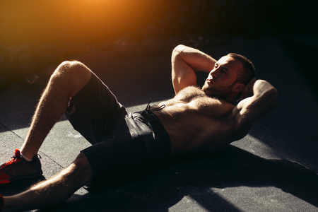 Muscular man exercising doing sit up exerciseの写真素材