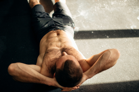 Muscular man exercising doing sit up exerciseの写真素材