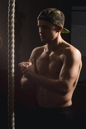 man doing Fitness Rope Climb Exercise In Fitness Gym Workout