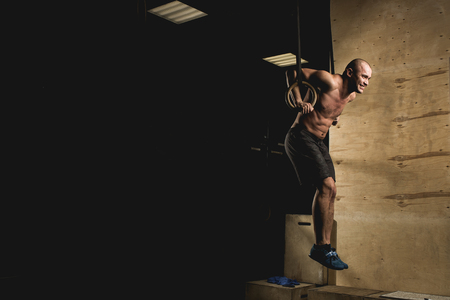 fit man pulling up on gymnastic rings.の写真素材