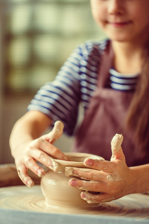 Female potter working at throwing wheel at studio. Clay workshopの写真素材