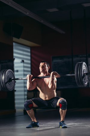 man naked torso doing exercise barbell gymの写真素材