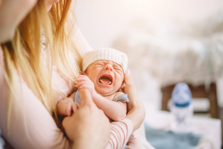 newborn cries in arms of his mother