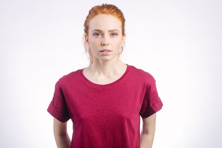 beautiful young redhead girl with clean fresh face and neutral emotions close upの写真素材