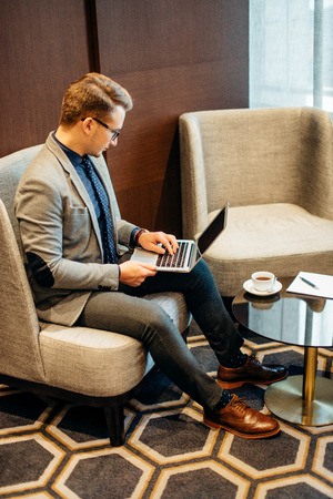 man works on laptop to business done early with cup of coffeeの写真素材