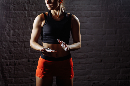 female athlete clapping hands with chalk powder before strength trainingの写真素材