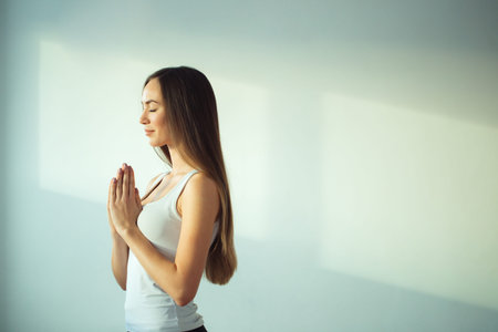 woman practicing yoga and meditation, holding palms together in namaste mudra