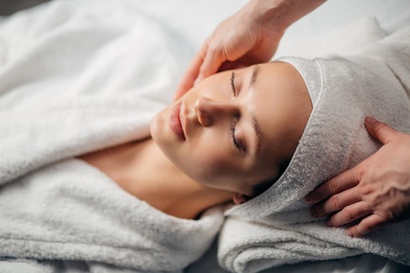 girl having spa facial massage in luxurious beauty salonの写真素材