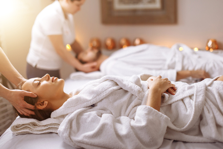 happy young beautiful couple enjoying head massage at the spaの写真素材