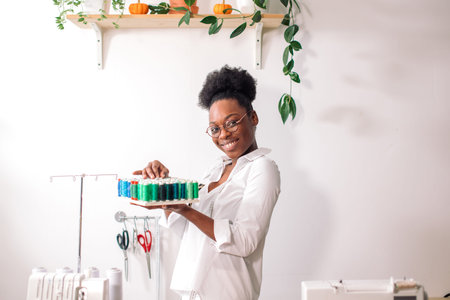 african seamstress holding coils with threads